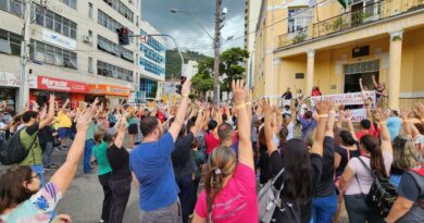 servidores municipais fazendo protestos com os braços levantados