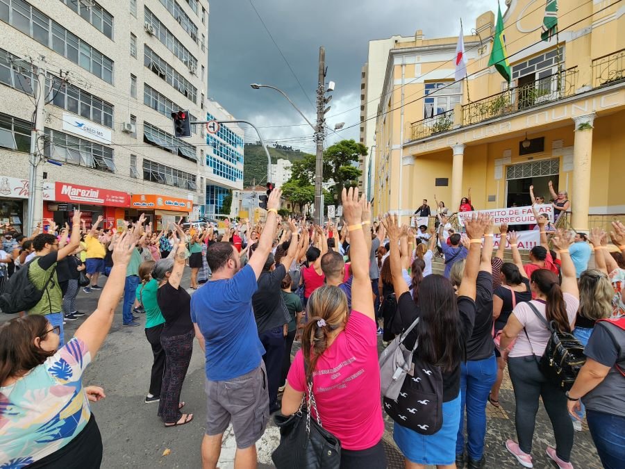 servidores municipais fazendo protestos com os braços levantados