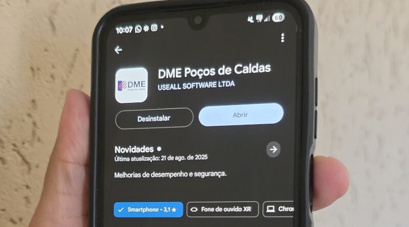 Mão segurando um celular com o aplicativo da Agência Virtual da DME de Poços de Caldas