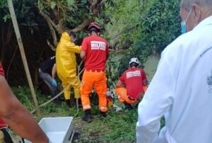 equipes do corpo de bombeiros e serviço funerário na remoção de um corpo às margens do rio lambari em Poços de Caldas-MG