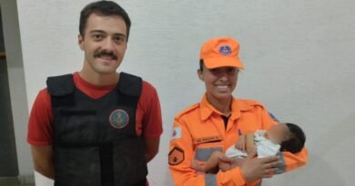 bebê de 7 dias no colo da bombeiro militar de Alfenas-MG após o salvamento. O recém nascido havia se engasgado.