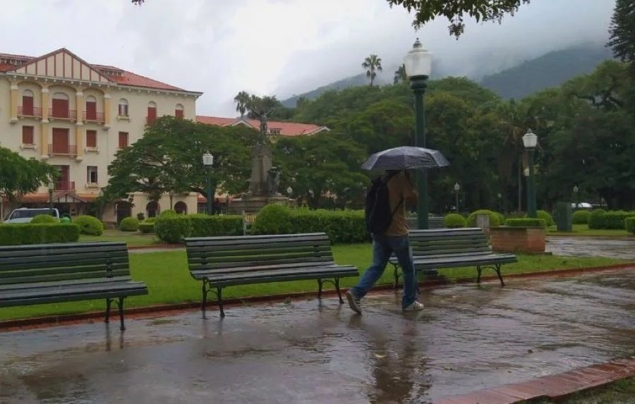 homem com guarda chuva na praça Pedro Sanches em Poços e Caldas-MG