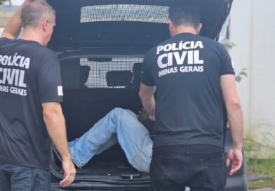 policiais civis colocando suspeito de tentativa de homicídio na viatura