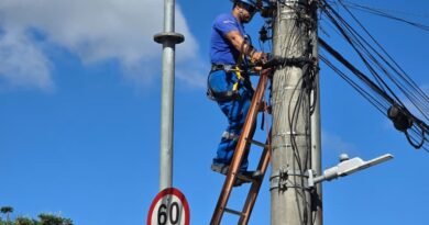 técnico do DME retirando fiação inutilizada de postes de Poços de Caldas