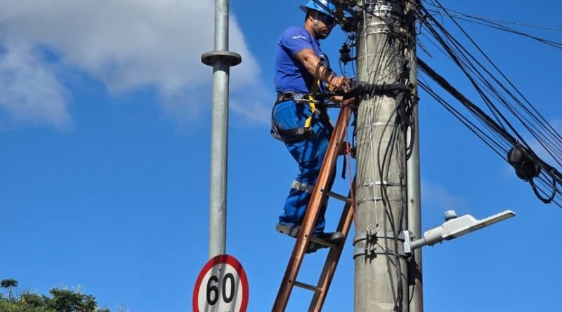 técnico do DME retirando fiação inutilizada de postes de Poços de Caldas