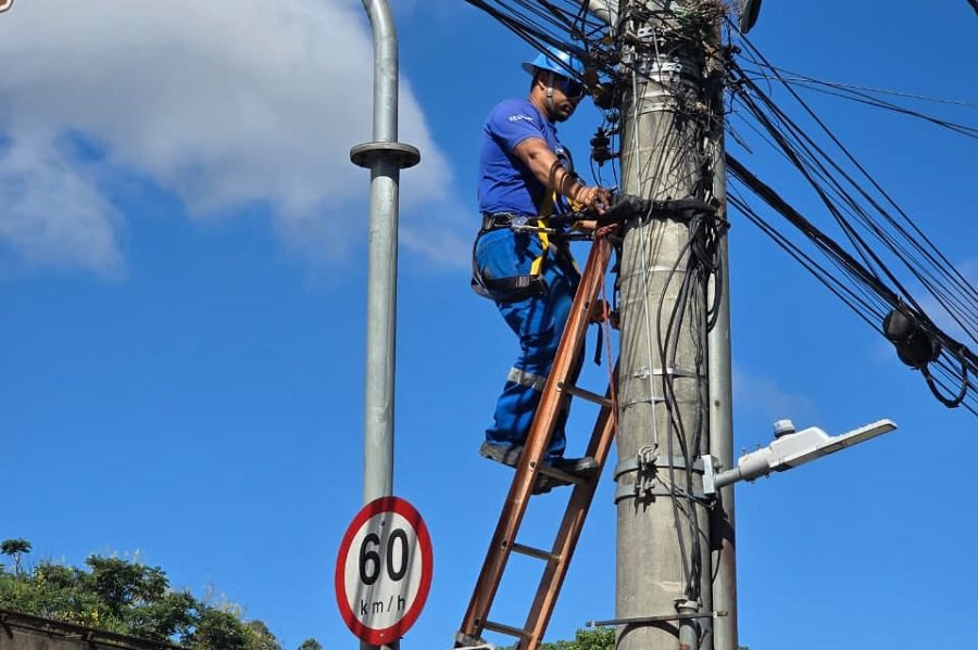 técnico do DME retirando fiação inutilizada de postes de Poços de Caldas