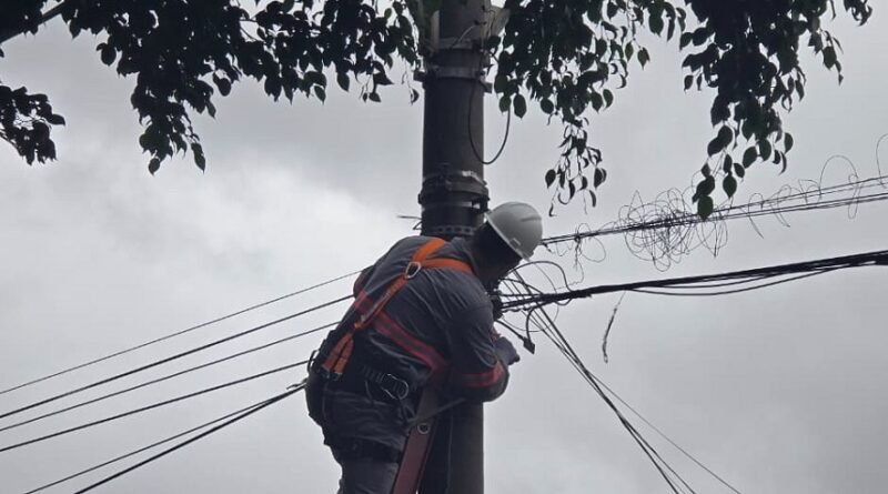 técnico do DME limpando fiação de internet e telefonia dos postes de iluminação pública