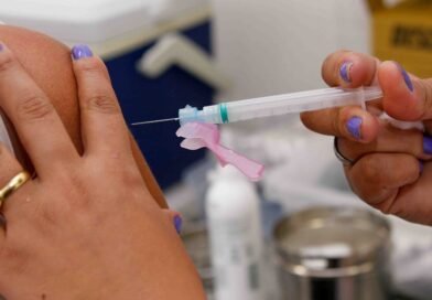 mão segurando uma seringa com vacina contra a gripe