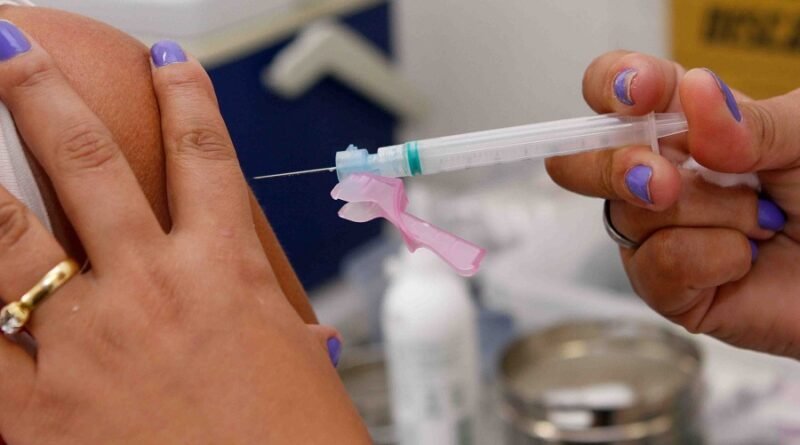 mão segurando uma seringa com vacina contra a gripe