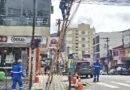 técnicos durante limpeza de fiação em postes na área central