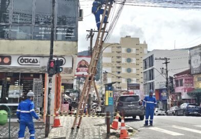 técnicos durante limpeza de fiação em postes na área central