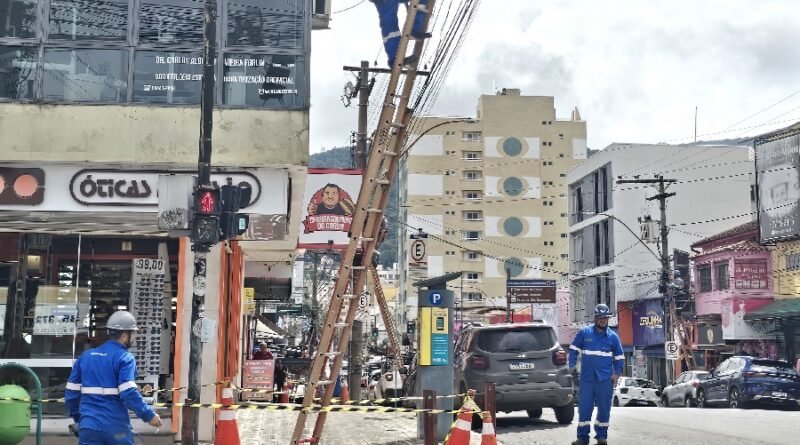 técnicos durante limpeza de fiação em postes na área central