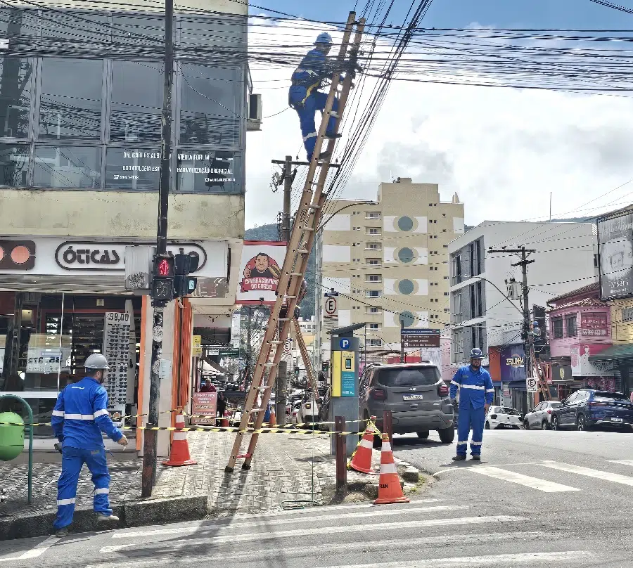 técnicos durante limpeza de fiação em postes na área central