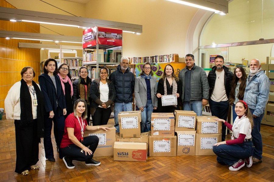 entrega de livros areecados durante o Flipoços 2026