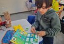Copa 2026: projeto pedagógico incentiva a escrita e empatia entre alunos de Cabo Verde aluno colando figurinha em album da copa