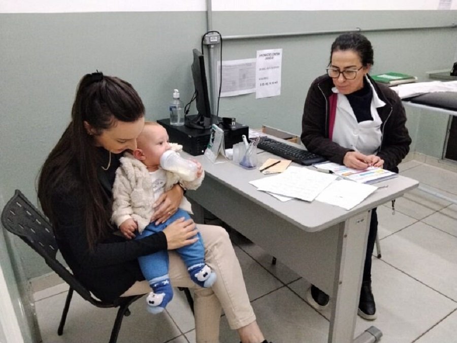 mãe com bebê no colo na sala de vacina