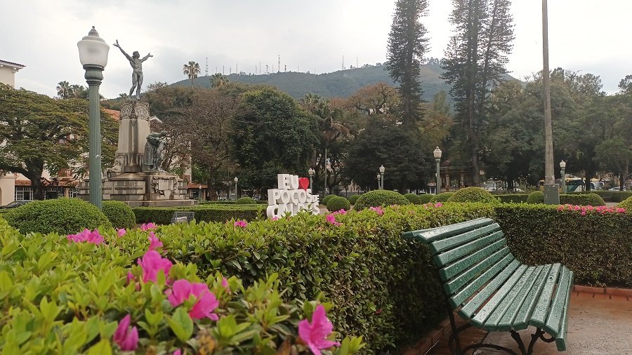 banco de praça, estátua do monumento minas ao brasil, arbustos e arvores na praça Pedro Sanches em Poços de Caldas-MG